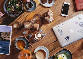 A group enjoying a diverse brunch spread with coffee on a rustic wooden table. Perfect for food and lifestyle themes.