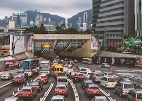 Heavy traffic congestion at Hong Kong's Cross-Harbour Tunnel with cityscape.
